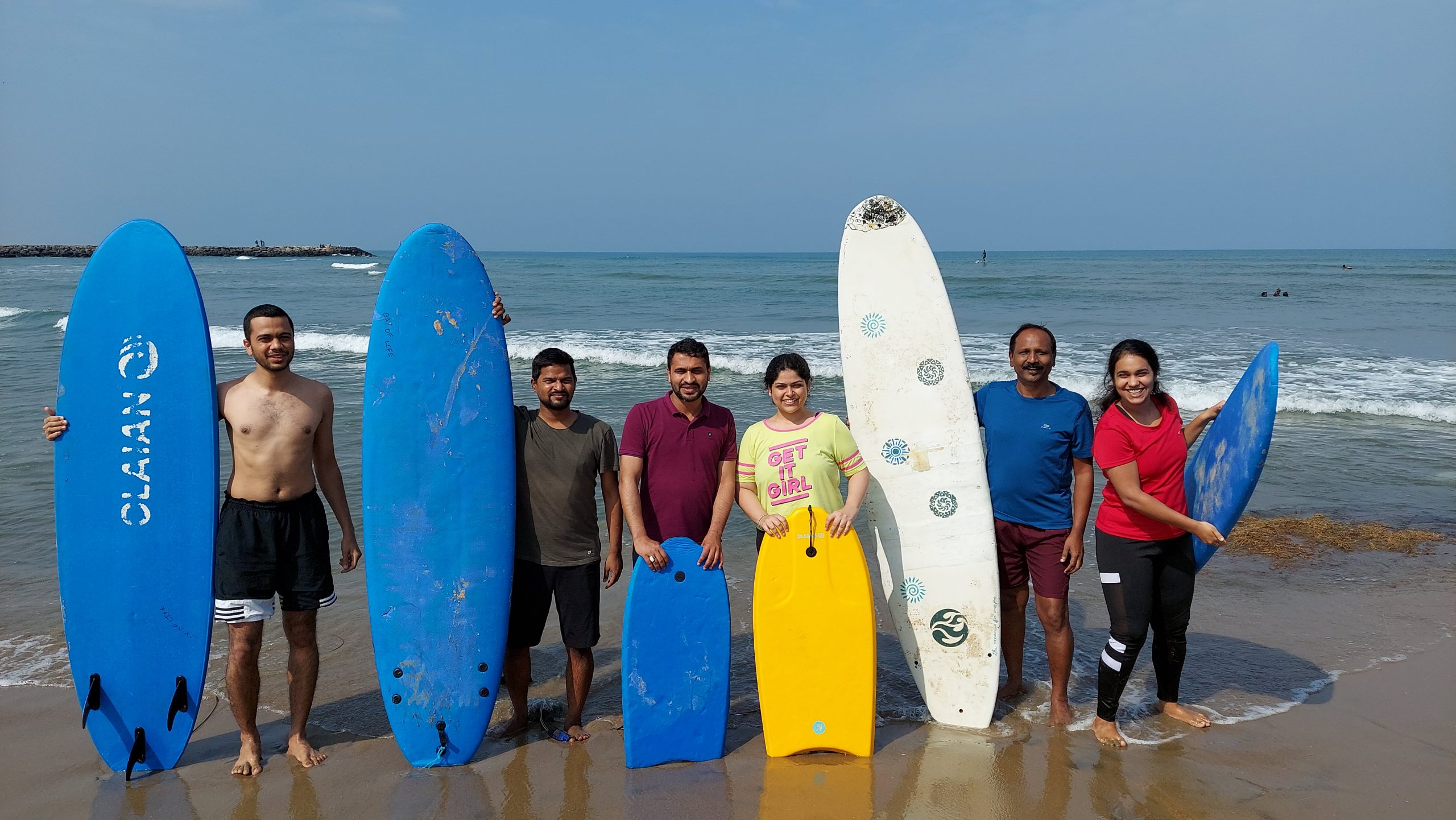 Students surfing the waves at Kovalam Beach